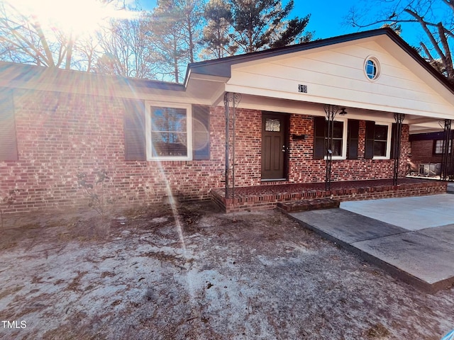 view of front of house with brick siding and a porch