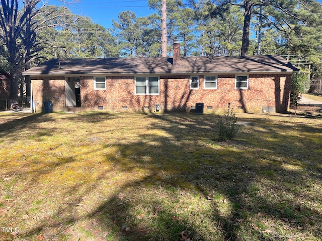 rear view of house featuring central AC, brick siding, a yard, crawl space, and a chimney