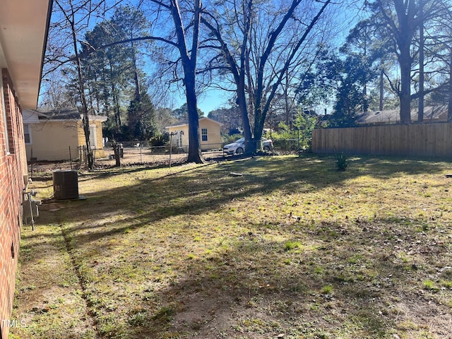 view of yard featuring central AC and fence