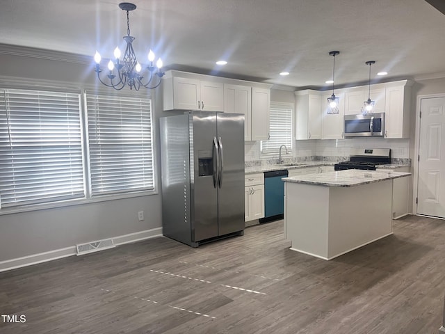 kitchen with visible vents, decorative backsplash, appliances with stainless steel finishes, white cabinetry, and a sink