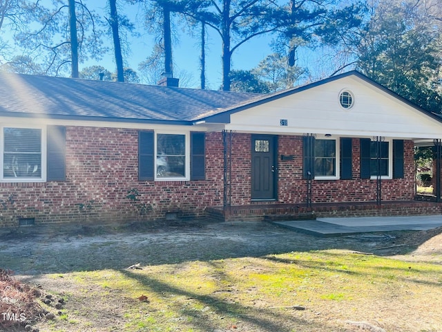 ranch-style house with brick siding, a shingled roof, crawl space, a chimney, and a front yard