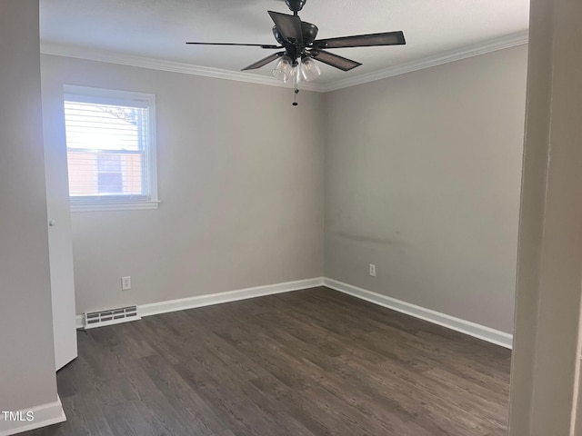 spare room with dark wood-style flooring, visible vents, ornamental molding, ceiling fan, and baseboards