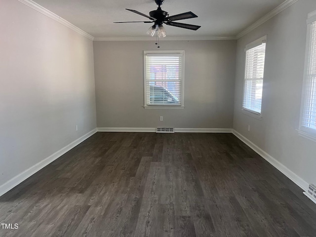 empty room featuring a wealth of natural light, visible vents, dark wood-style flooring, and crown molding