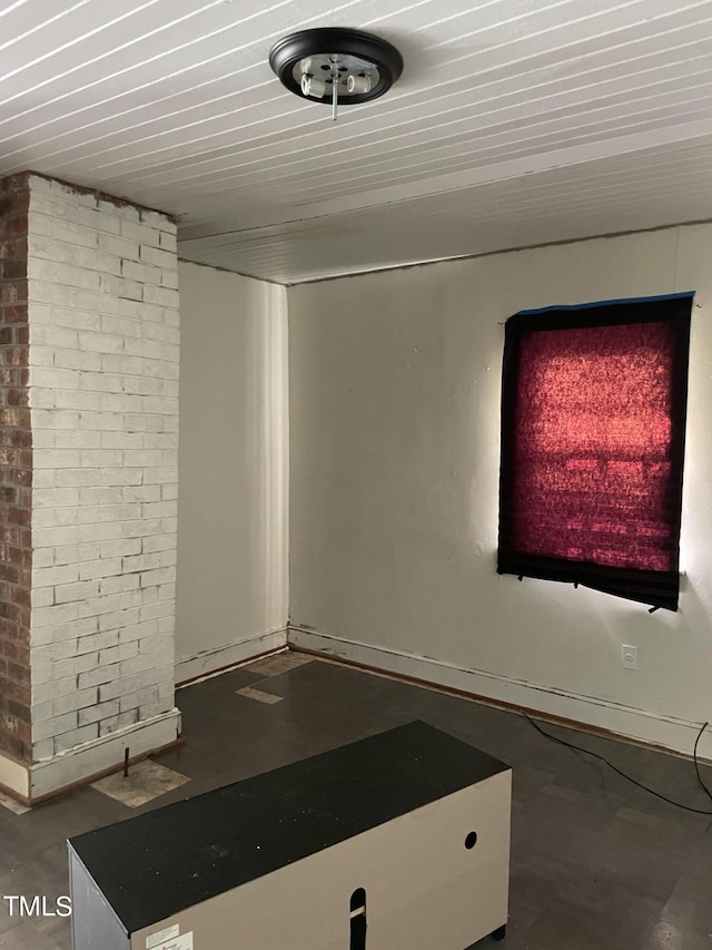 interior space with finished concrete flooring and brick wall