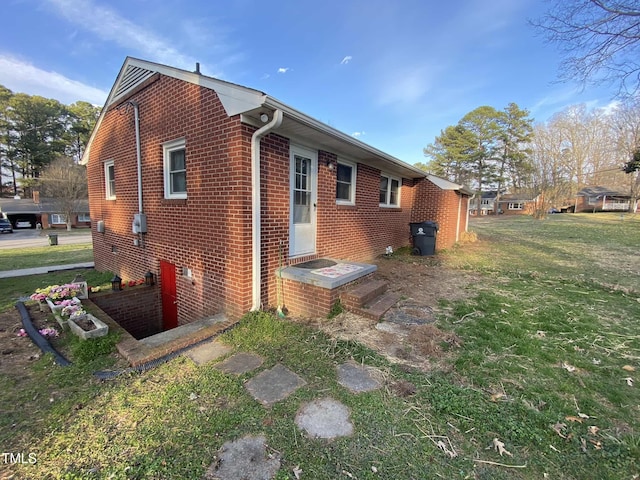 view of side of property featuring a yard and brick siding