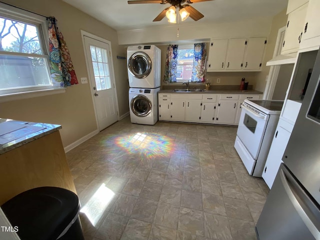 kitchen with stacked washer and dryer, a sink, white range with electric stovetop, and white cabinetry
