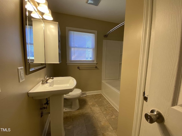 bathroom with baseboards, toilet, and tub / shower combination