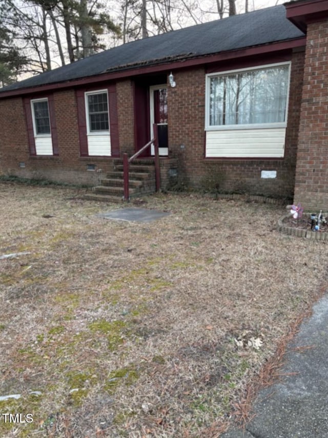 ranch-style house featuring entry steps, brick siding, and crawl space