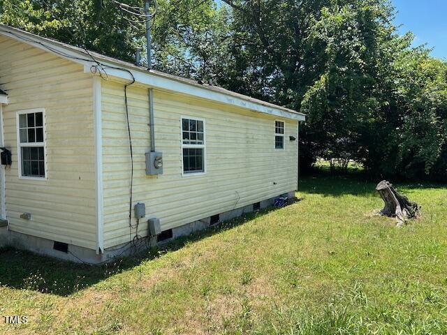 view of home's exterior with crawl space and a yard