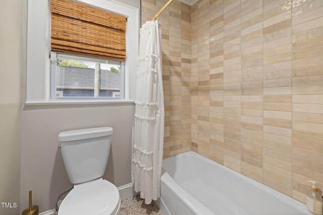 full bathroom with baseboards, shower / bath combo with shower curtain, and toilet