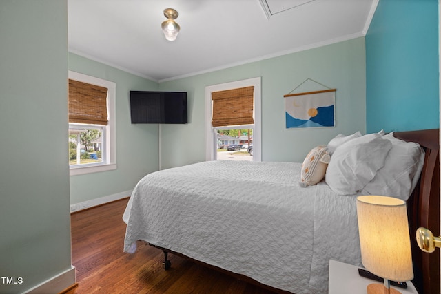 bedroom featuring crown molding, baseboards, multiple windows, and wood finished floors