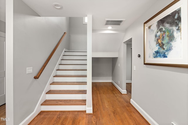 stairs with baseboards, recessed lighting, wood finished floors, and visible vents