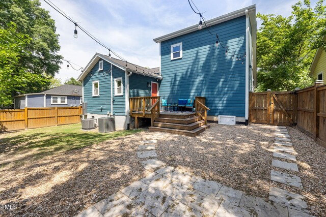 rear view of house with a deck, cooling unit, and a fenced backyard