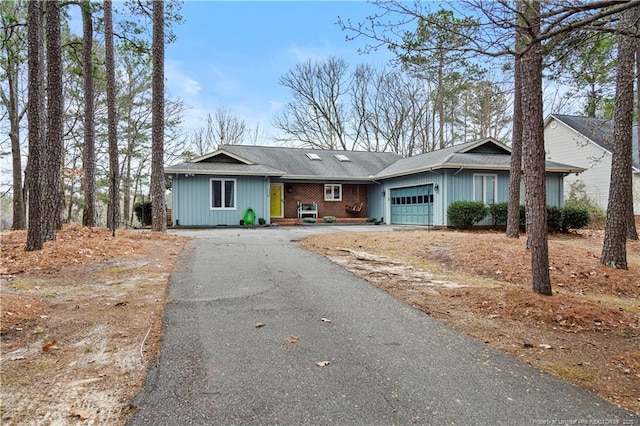 ranch-style house with a garage, driveway, and brick siding