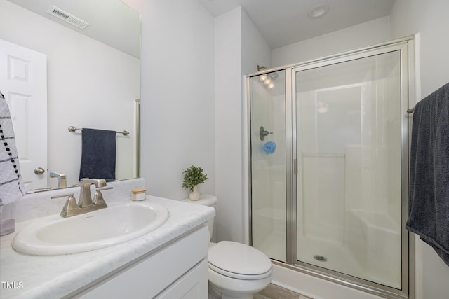 full bathroom with toilet, a stall shower, visible vents, and vanity