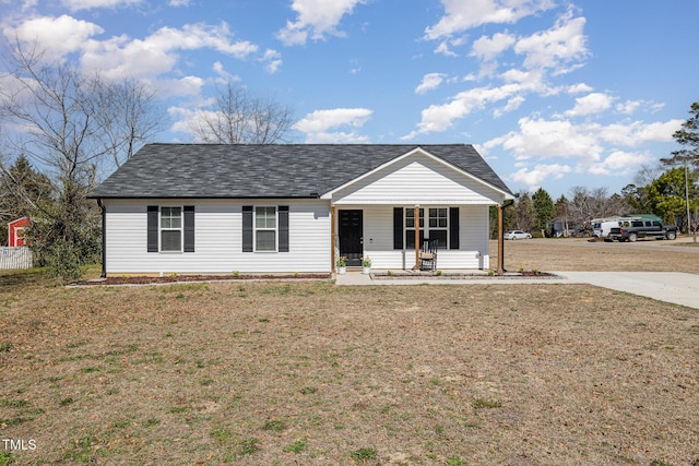 view of front of home with covered porch, a front lawn, and a shingled roof