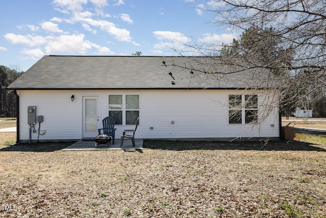 back of property featuring a shingled roof and a patio