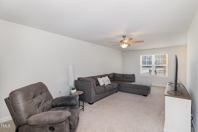 living room with baseboards, a ceiling fan, and light colored carpet