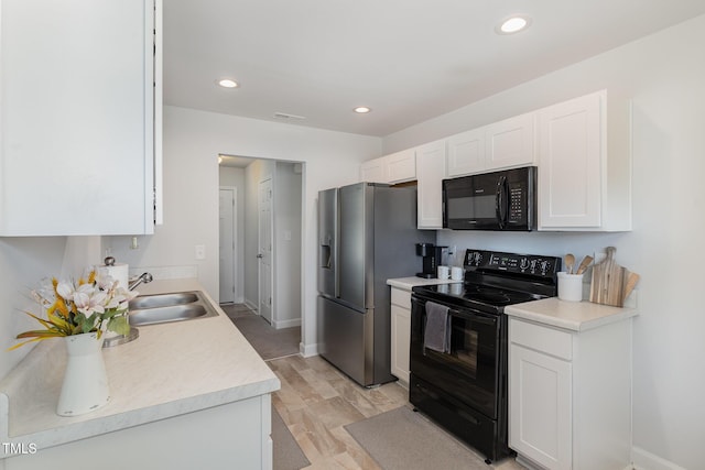 kitchen with visible vents, light countertops, black appliances, white cabinetry, and a sink