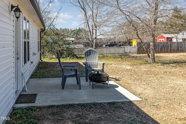 view of yard with a patio area, fence, and a fire pit