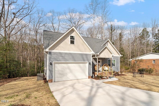 view of front of property featuring a shingled roof, concrete driveway, an attached garage, a front lawn, and central AC