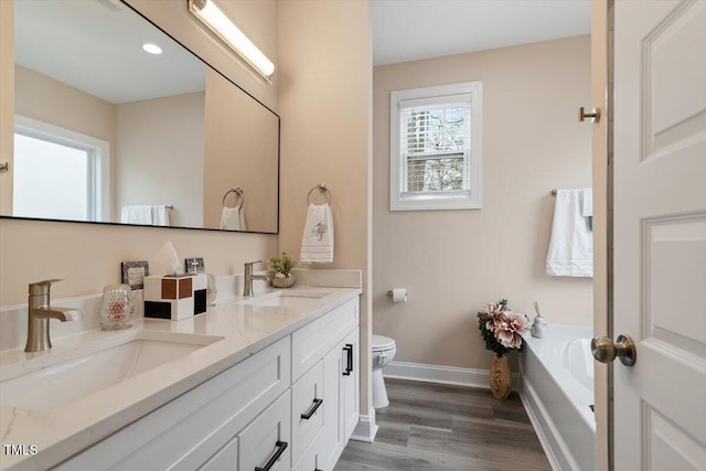 full bath with wood finished floors, a sink, toilet, and baseboards