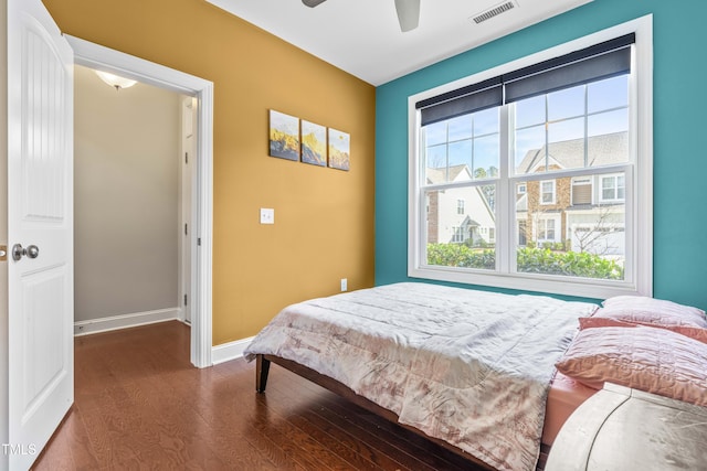 bedroom with ceiling fan, dark wood finished floors, visible vents, and baseboards