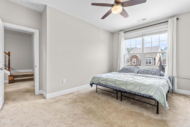 bedroom featuring ceiling fan, light colored carpet, visible vents, and baseboards