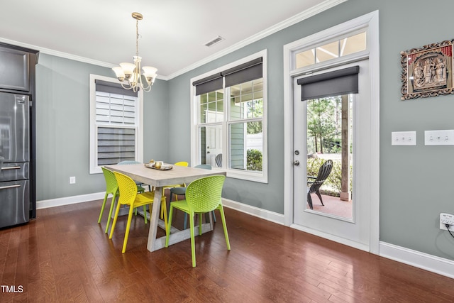 dining space featuring dark wood-type flooring, visible vents, ornamental molding, and baseboards