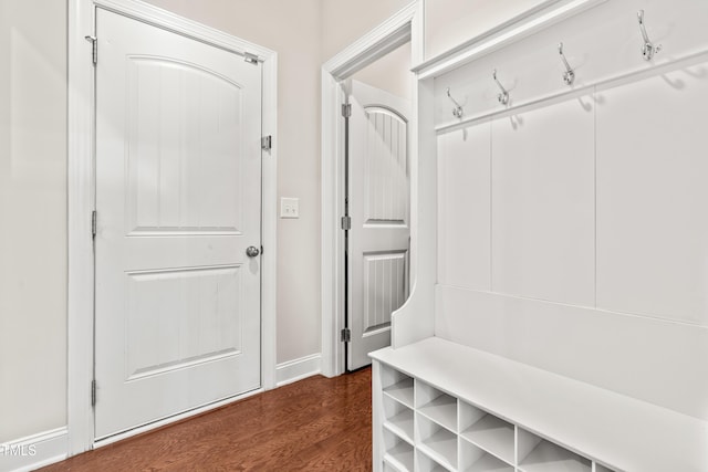 mudroom with dark wood-style floors and baseboards