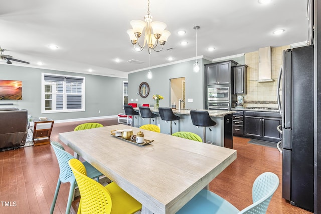 dining area featuring dark wood-style floors, recessed lighting, ornamental molding, and baseboards