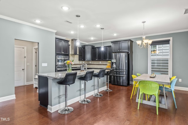 kitchen with light stone counters, dark wood-style flooring, visible vents, appliances with stainless steel finishes, and a kitchen bar