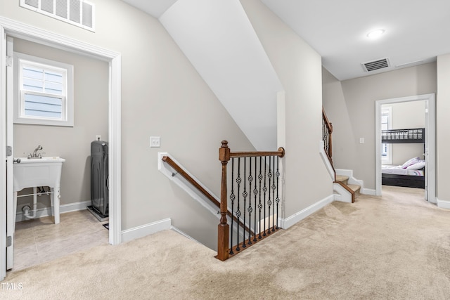 stairs with carpet, visible vents, and baseboards