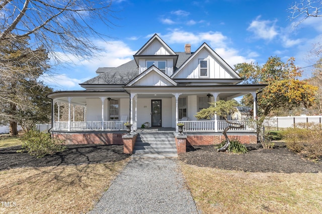 view of front of house featuring covered porch, fence, roof with shingles, board and batten siding, and a chimney