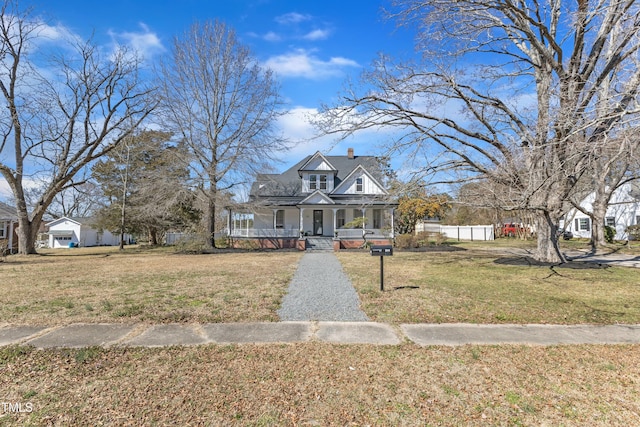 view of front of property featuring a porch, a chimney, a front yard, and fence