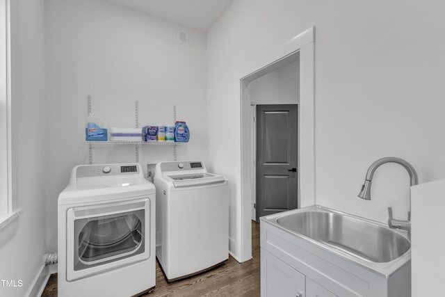 laundry area with baseboards, visible vents, dark wood-type flooring, washer and dryer, and a sink