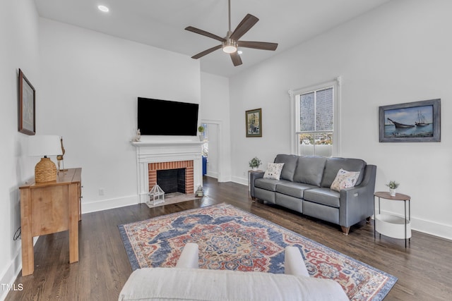 living room featuring a fireplace, baseboards, wood finished floors, and recessed lighting