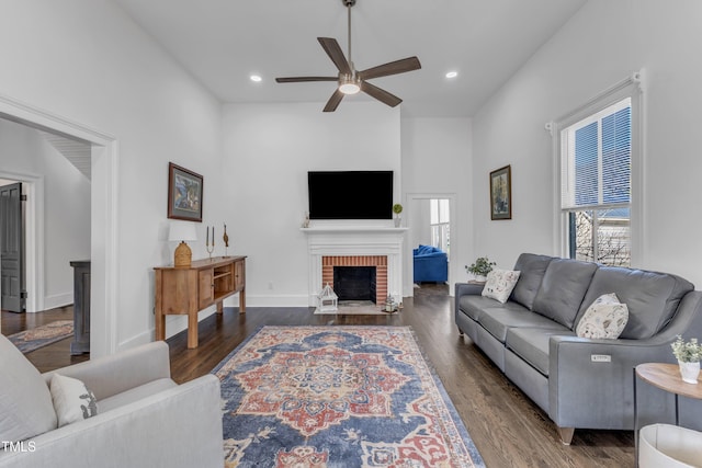 living area with a ceiling fan, recessed lighting, a fireplace, and wood finished floors