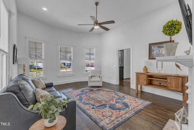 living area with a ceiling fan, recessed lighting, dark wood-style flooring, and baseboards