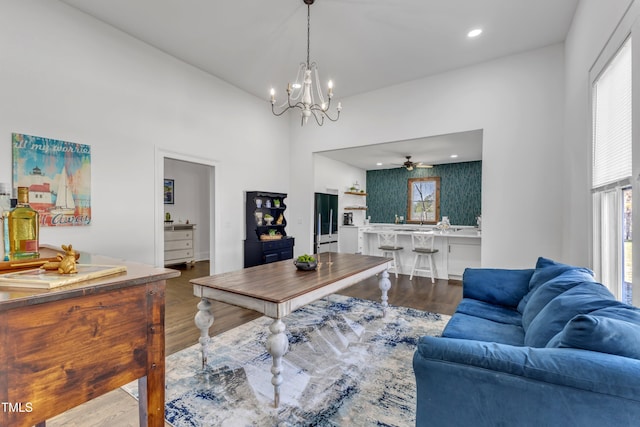 living area featuring ceiling fan with notable chandelier, plenty of natural light, wood finished floors, and recessed lighting