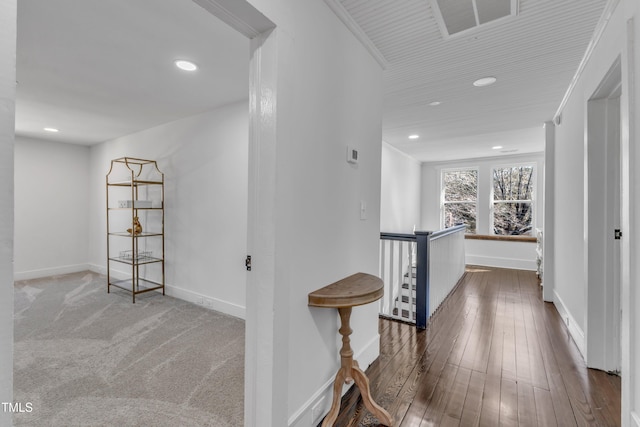 hallway with baseboards, crown molding, hardwood / wood-style floors, and an upstairs landing