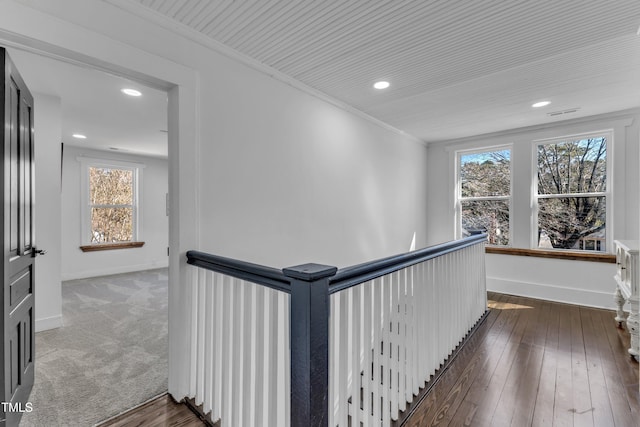 hallway featuring an upstairs landing, crown molding, and baseboards