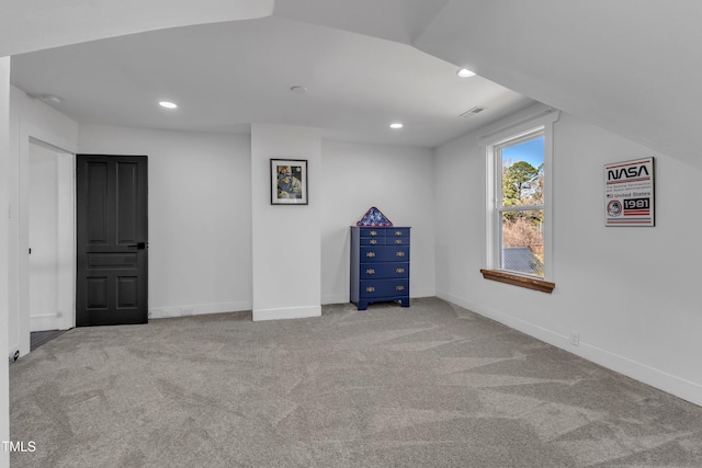 interior space with carpet, baseboards, vaulted ceiling, and recessed lighting