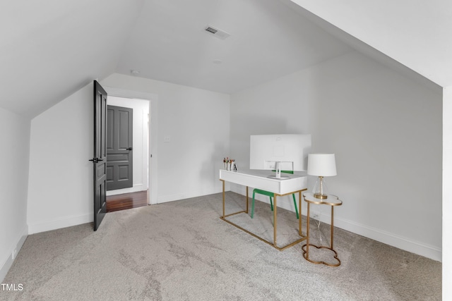 carpeted office space with lofted ceiling, baseboards, and visible vents