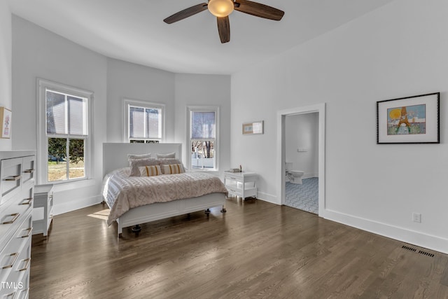 bedroom with dark wood-style flooring, ensuite bath, visible vents, and baseboards