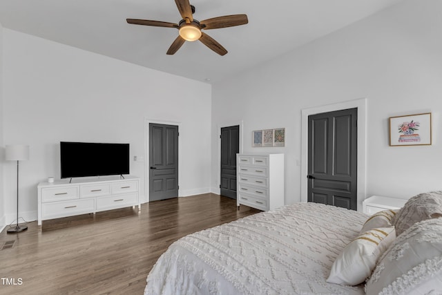 bedroom featuring a ceiling fan, visible vents, baseboards, and dark wood-style flooring