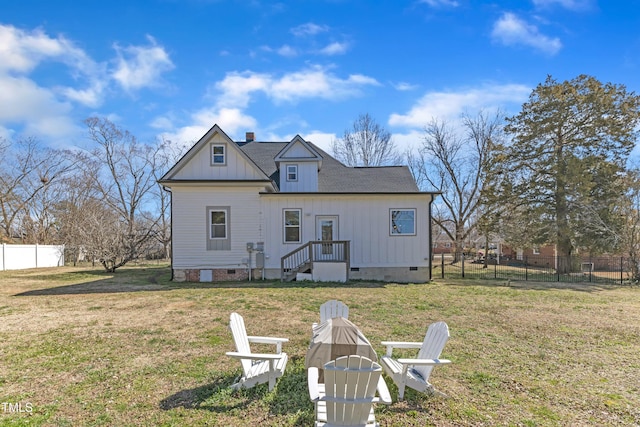 rear view of house featuring a fire pit, a chimney, crawl space, fence, and a yard