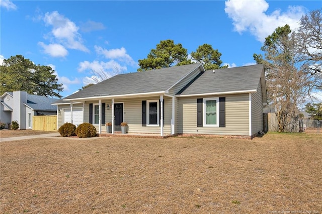 single story home featuring a porch, a front lawn, fence, and an attached garage