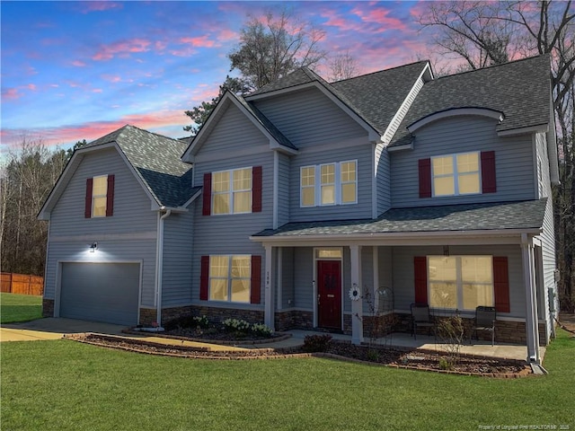 view of front of property with a garage, concrete driveway, a lawn, and roof with shingles