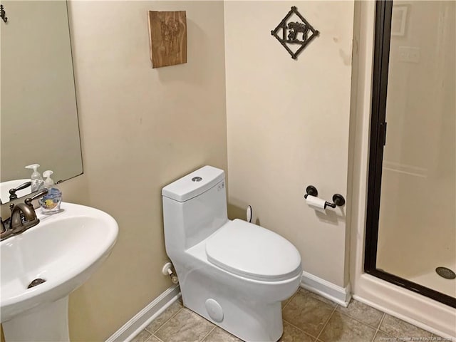 bathroom with toilet, a stall shower, a sink, and tile patterned floors